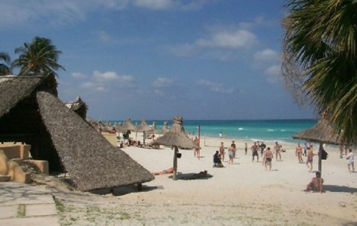 Personas disfrutando de su tiempo libre en la playa tomando el sol ¿te apetece?